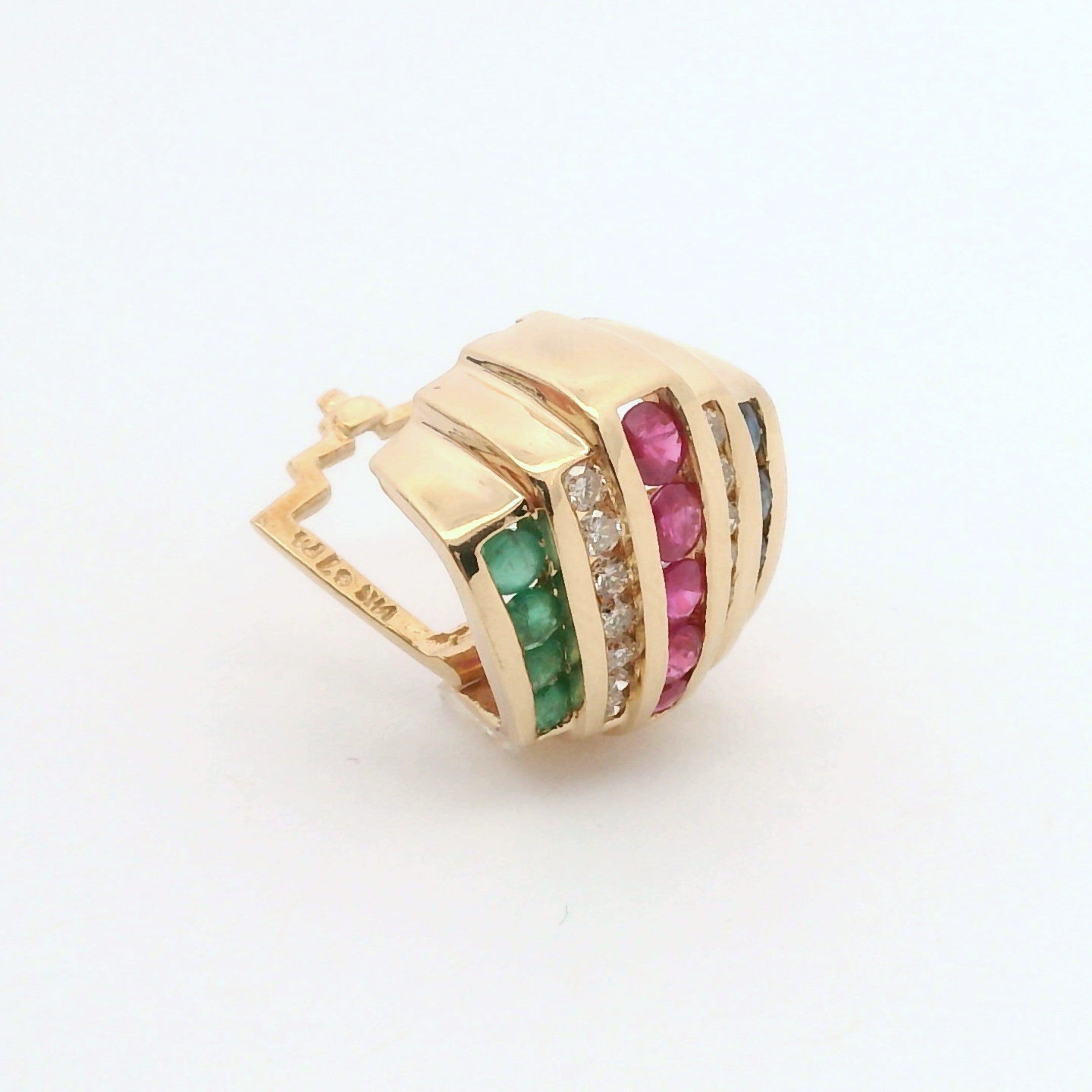 Gold slide pendant with green and red gemstones on a white background